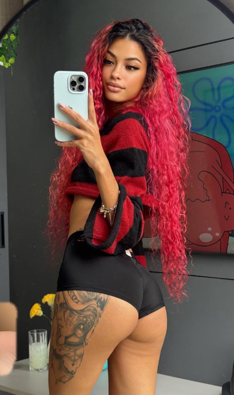 Renata Lima, a red-haired Latina OnlyFans creator, showing a detailed thigh tattoo in a mirror selfie