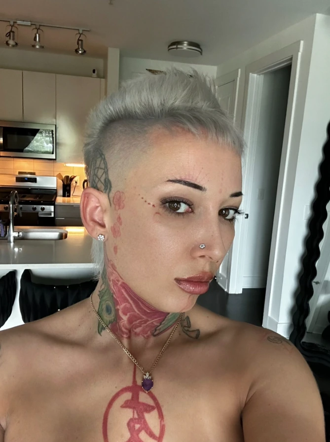 Bella Bellz, tattooed Native American OnlyFans creator, in a kitchen selfie with platinum hair