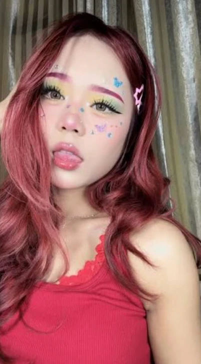 Candy Grettel with red hair and butterfly face stickers, the Estonian half of HG Couple