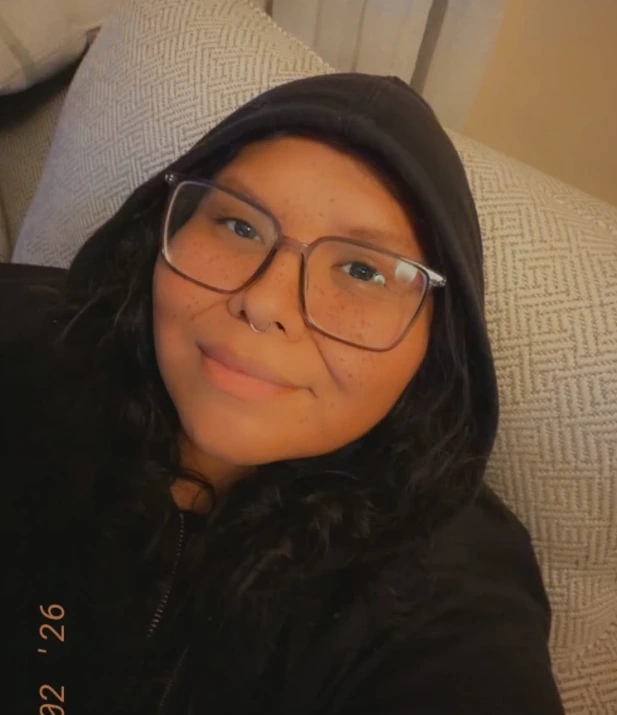 Lydia Grey smiling in a black hoodie and glasses